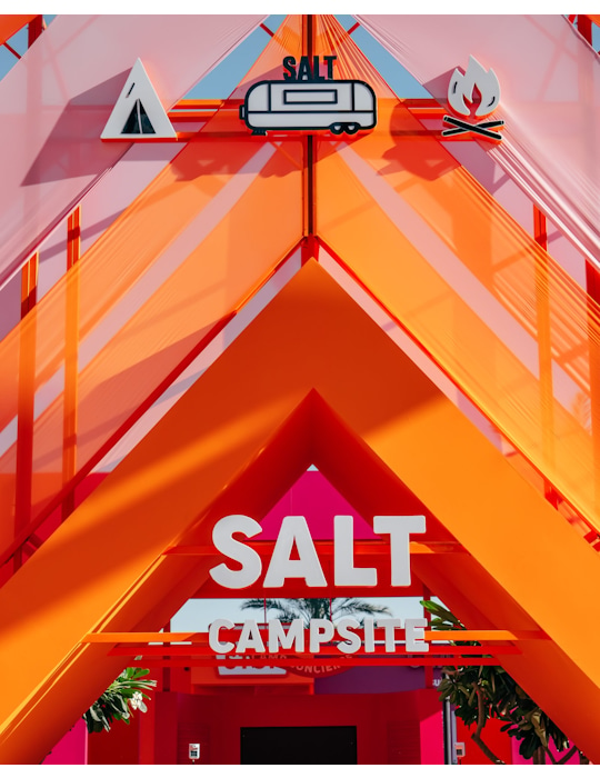 Studio Königshausen’s design for SALT CAMP in Dubai redefines camping for foodies, blending the charm of the great outdoors with a touch of glamour. We’ve created two dining areas, one for SALT and one for Sugar, offering savory meals and sumptuous desserts. The space is filled with interactive features, including a camping store, campfire confession table, and a stargazing area, all reflecting the brand’s personality. Königshausen: your partner in design, concept development, and scenography.